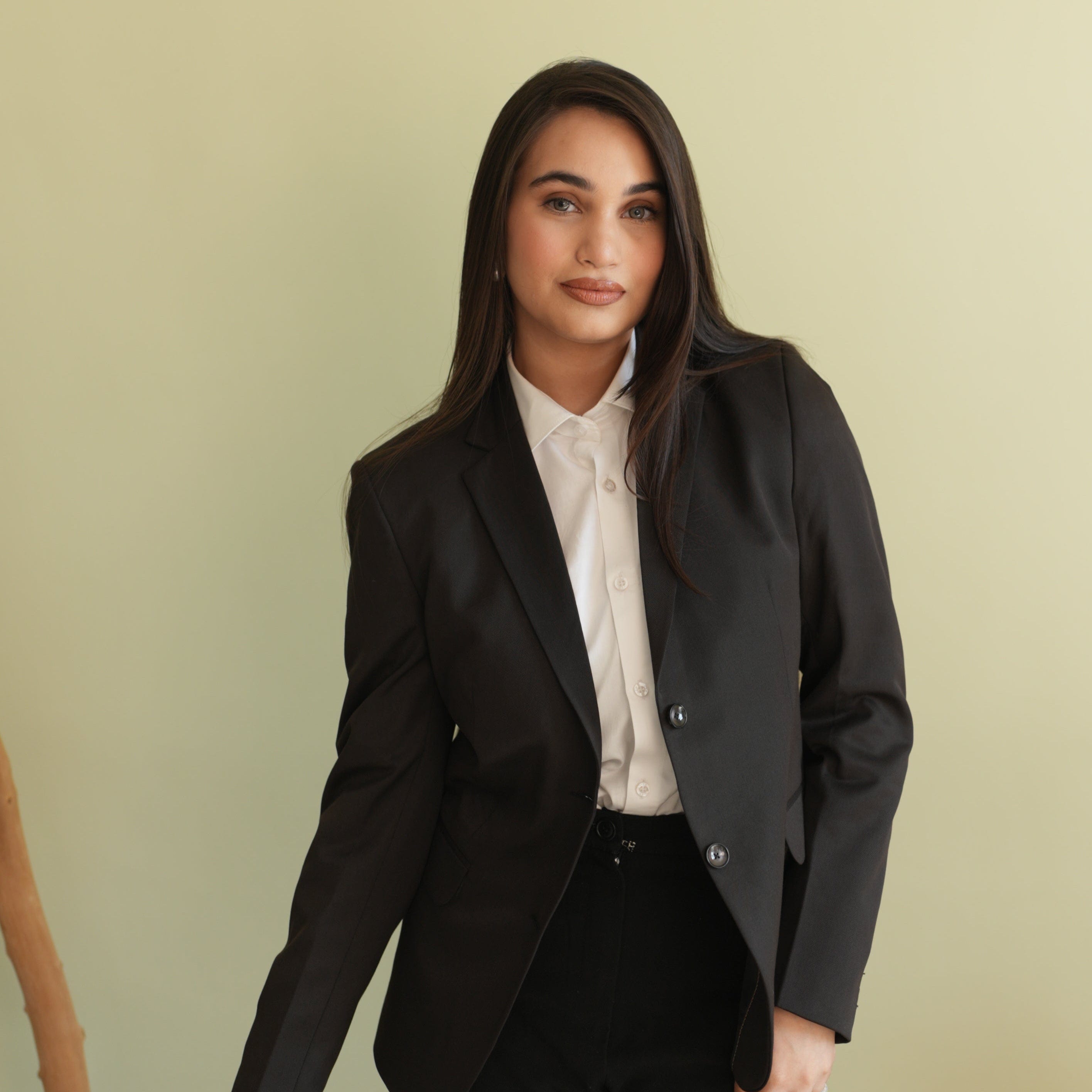 Woman wearing a black blazer over a white shirt against 