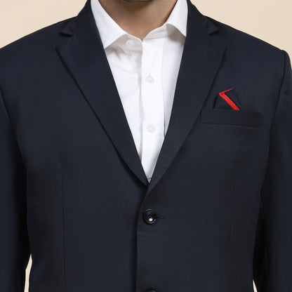 Navy suit jacket with a white shirt and red pocket square on a beige background